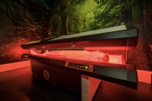 Patient relaxing in NovoTHOR red light pod for full-body pain relief and recovery at Acupuncture Zen, Delray Beach