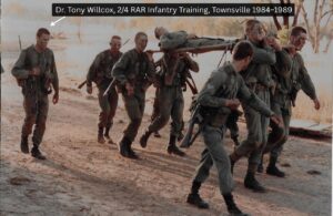 Dr. Tony Willcox far left in full combat gear with cam face paint carrying out a casualty stretcher evacuation exercise during Australian Army infantry field training with the 2nd/4th Battalion Royal Australian Regiment Townsville 1984