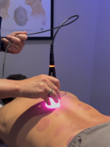 Dr. Tony Willcox performing K-Laser therapy on a patient's back at Acupuncture Zen in Delray Beach, FL