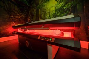 Patient lying inside a NovoTHOR whole body red light therapy pod during a photobiomodulation session at Acupuncture Zen in Delray Beach FL