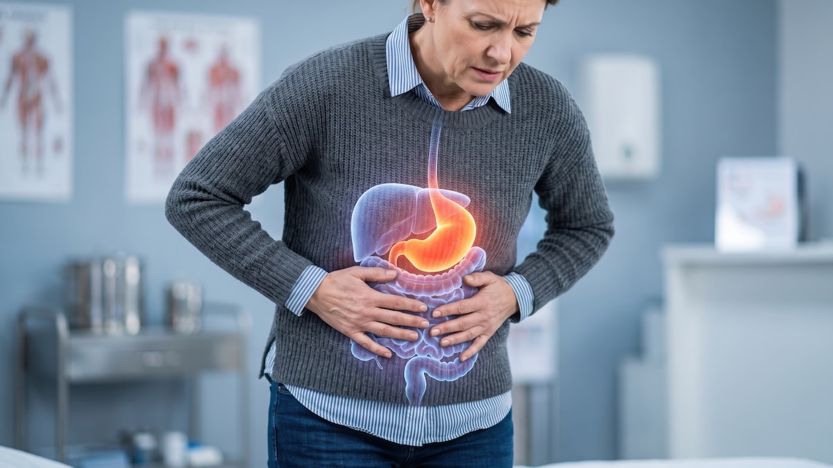 Woman holding her stomach in discomfort with a digestive system overlay highlighting the stomach and intestines