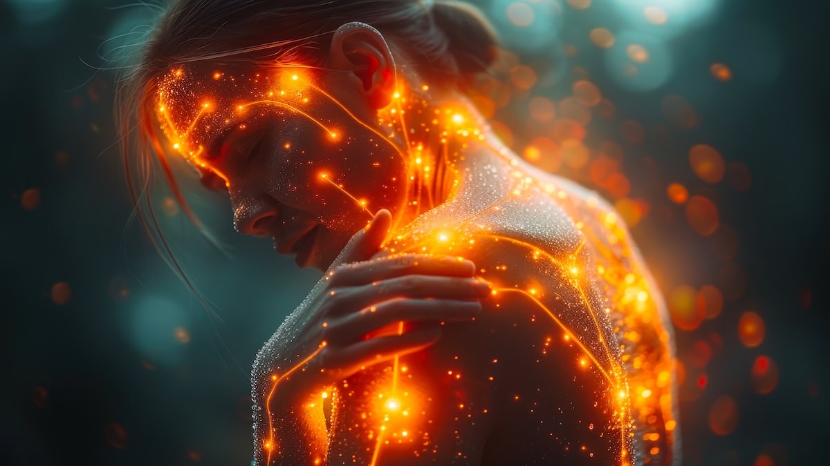 Woman holding her shoulder with glowing points of light across her body illustrating the widespread pain of fibromyalgia