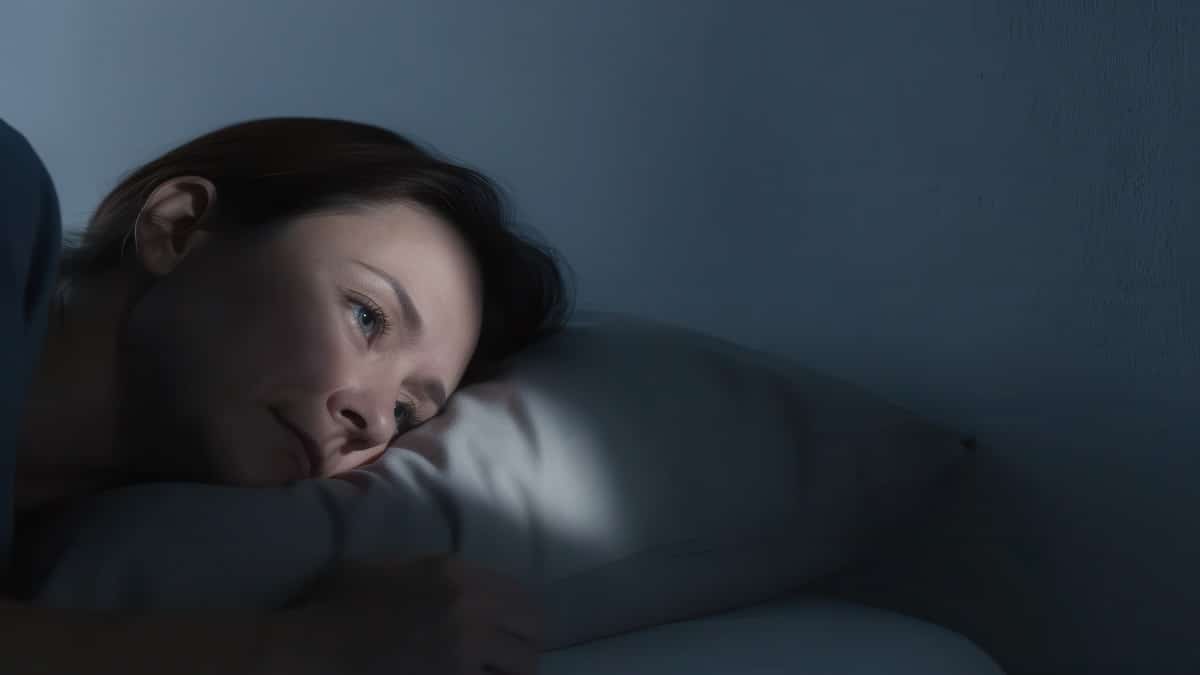 Woman lying awake in bed at night unable to sleep, insomnia acupuncture in Delray Beach
